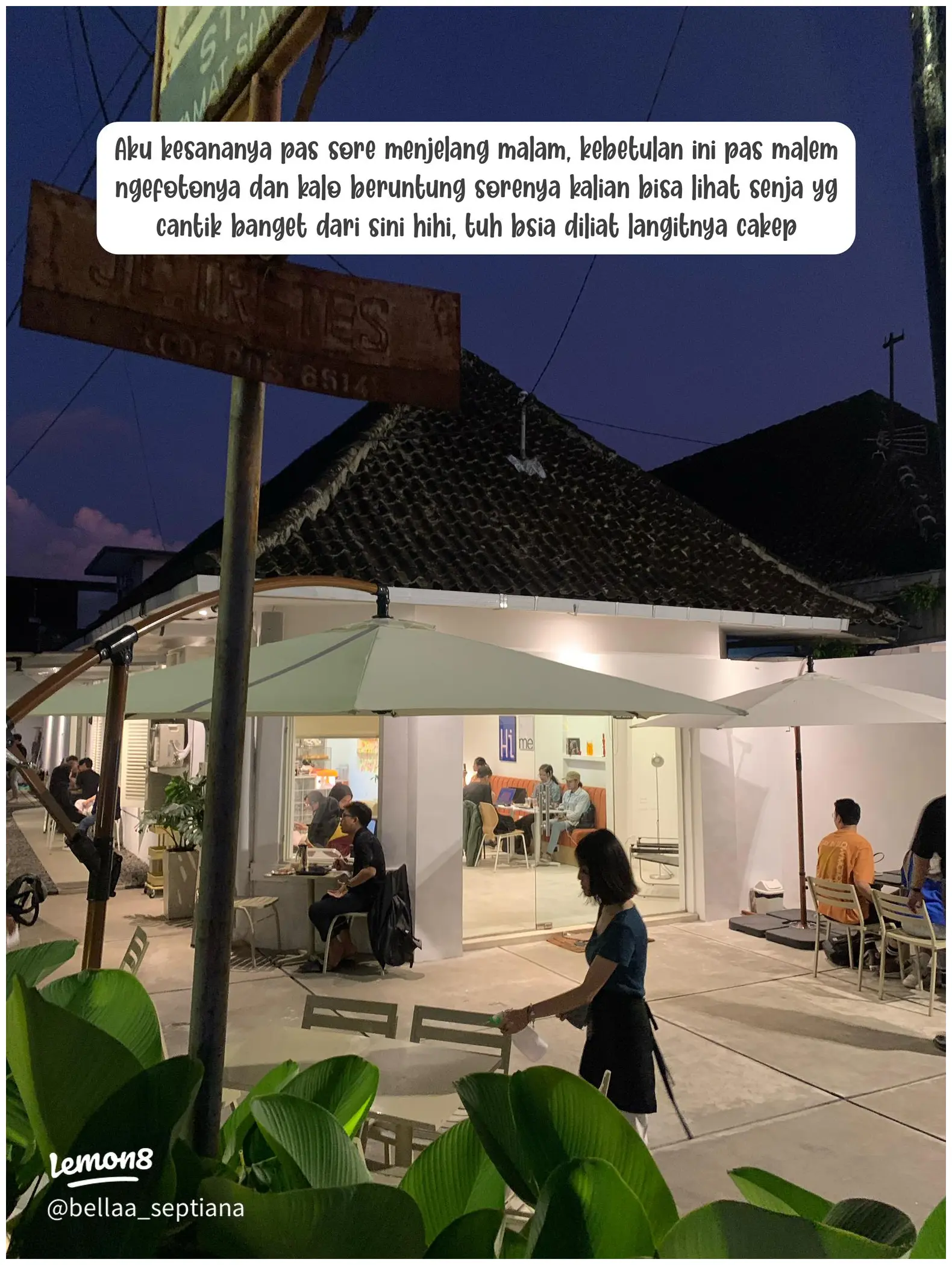 Ambil foto detail sudut meja dengan laptop, charger, dan secangkir kopi, menonjolkan suasana produktif.