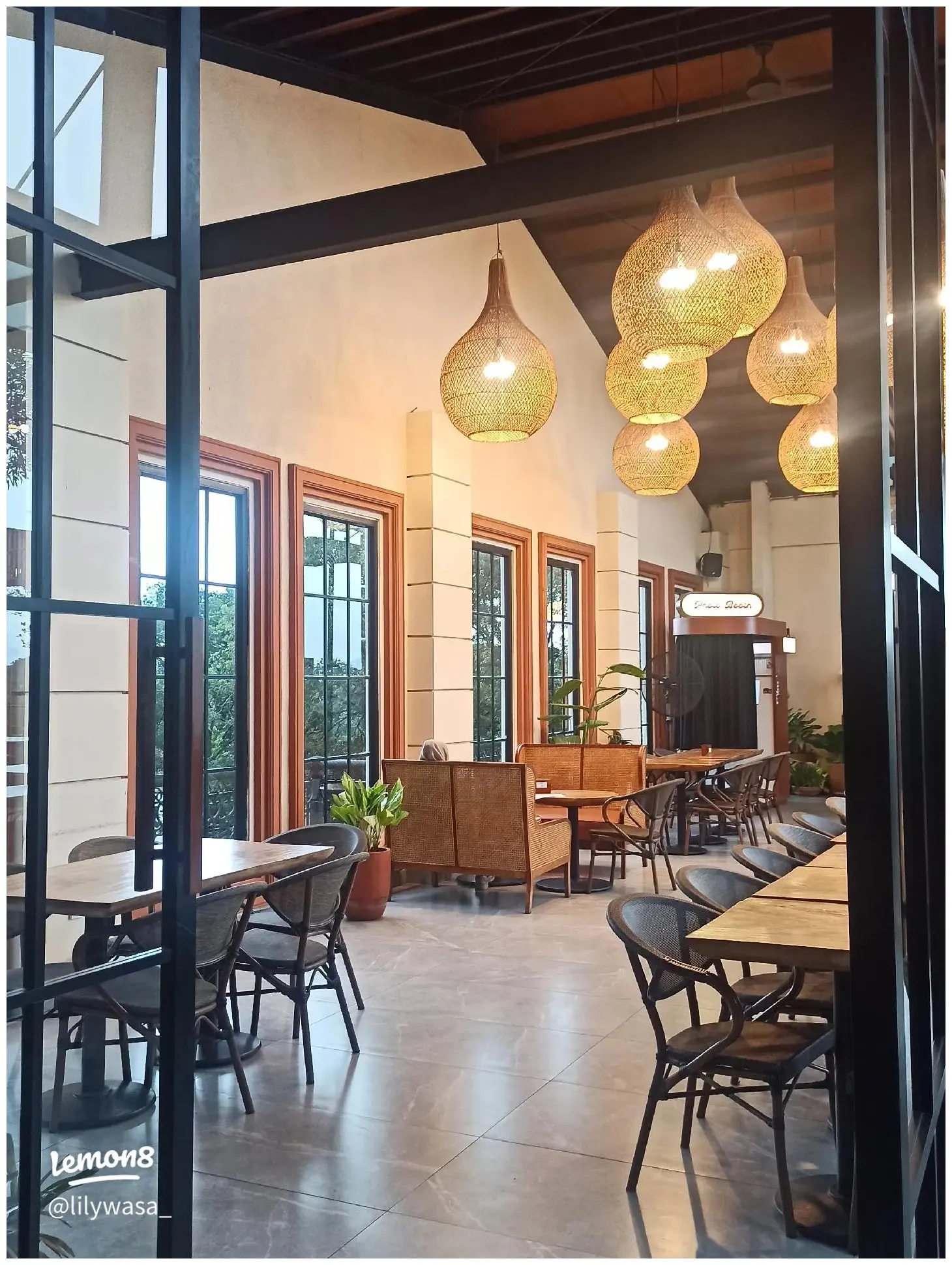 Ambil foto close-up cangkir kopi dengan latar belakang jendela besar di