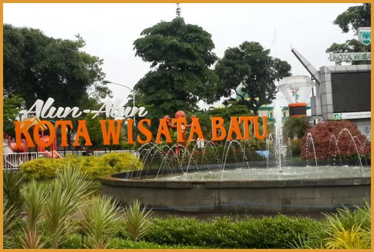 Ambil sudut pandang (angle) rendah di depan wahana bianglala Alun-Alun Batu saat lampu mulai menyala di sore hari untuk hasil foto yang dramatis.