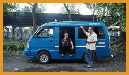 Potret suasana sibuk Terminal Landungsari dengan deretan angkot ungu yang berlatar belakang Gunung Arjuno di kejauhan.