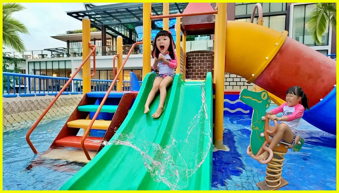 Ekspresi anak-anak saat bermain di water slide kolam air hangat Golden Tulip dengan uap air yang terlihat tipis di pagi hari.