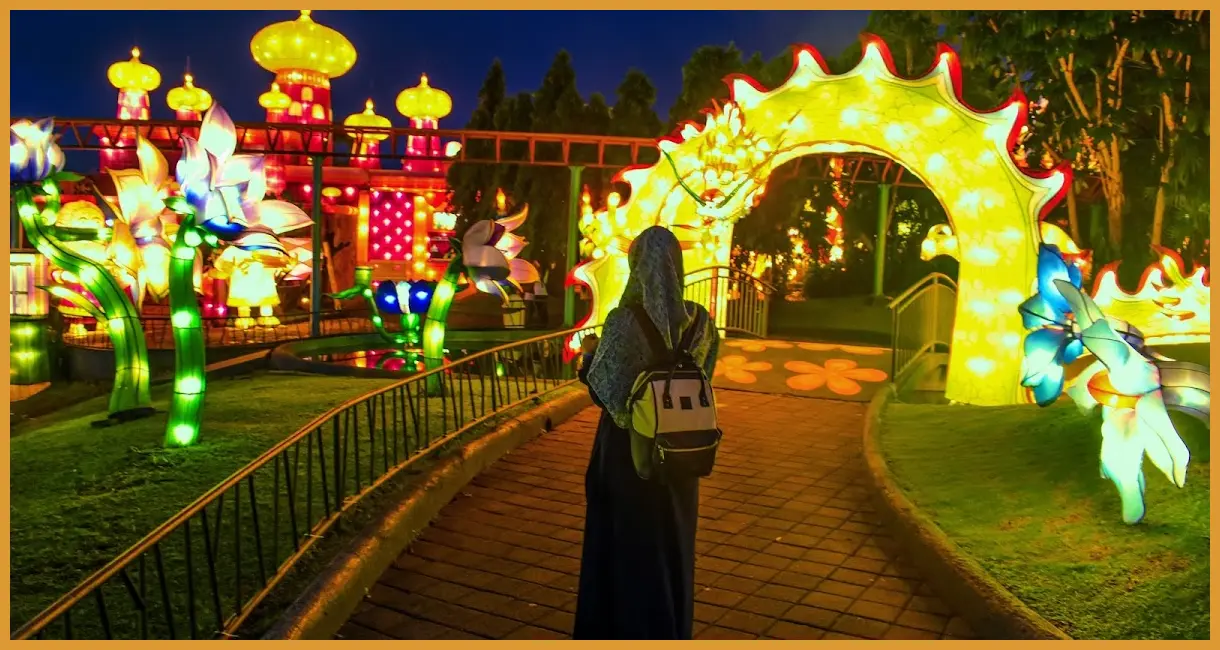 Ambil sudut rendah di tengah Lampion Garden untuk mendapatkan pantulan cahaya warna-warni pada latar belakang gelap yang kontras.