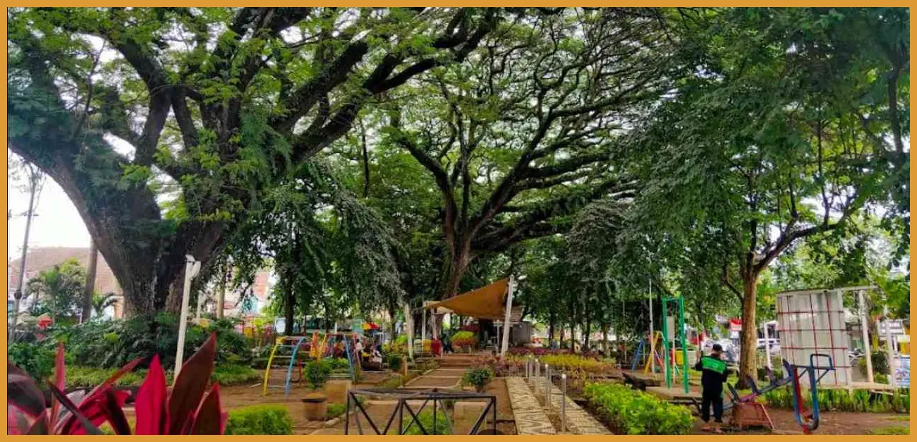 Ambil foto dari sudut rendah (low angle) di area taman untuk menangkap kontras antara hijaunya tanaman dengan material beton ekspos bangunan kafe.