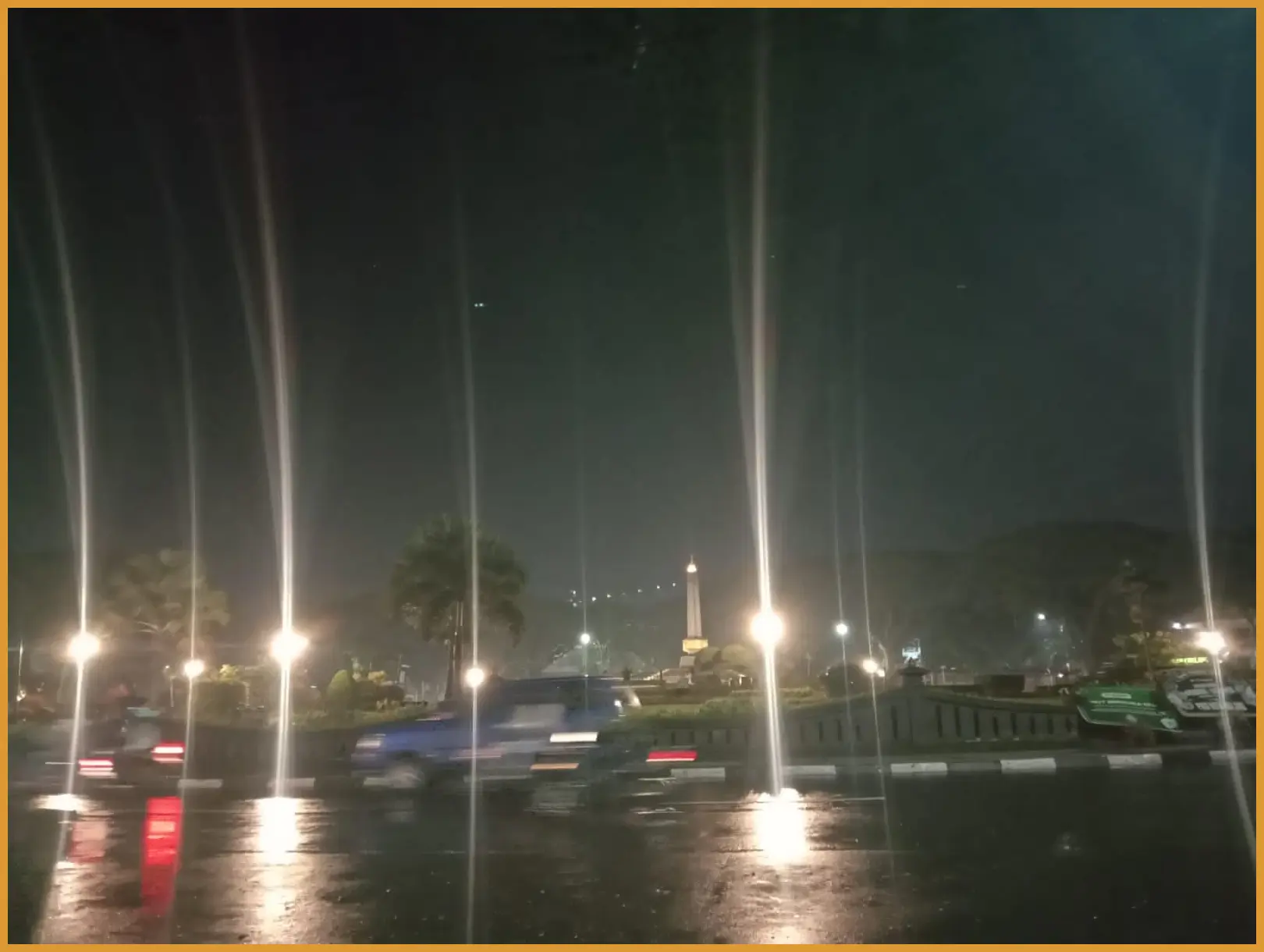 Ambil foto dengan teknik long exposure saat rintik hujan mulai turun di bawah lampu gantung cafe untuk menciptakan efek bokeh yang dramatis.